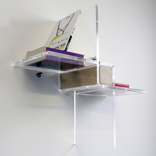 Geometric interlocking bookcase, made of curved plexiglass with a solid wood central section.